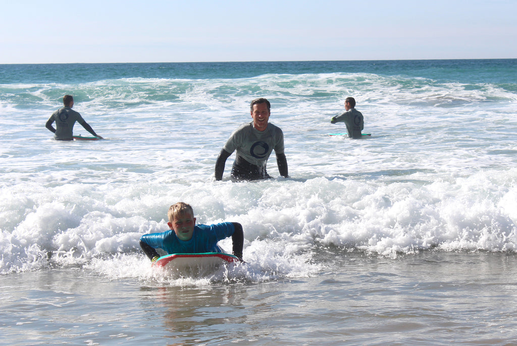 Four surfers riding the waves at a beach