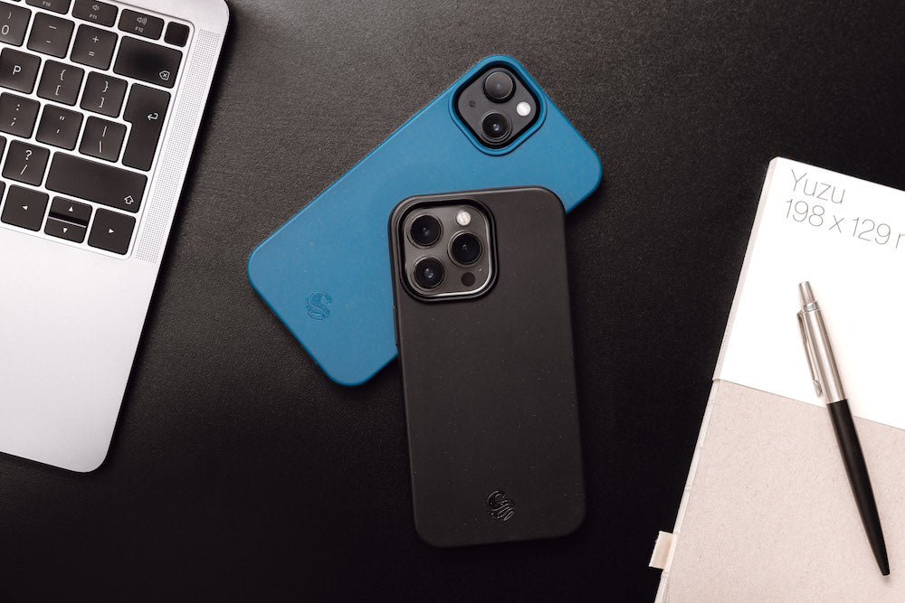 Two iPhones with sustainable phone cases laid on desk